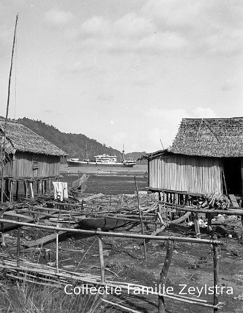 negatief-006.jpg - Papuahuisjes met Kaloekoe op achtergrond